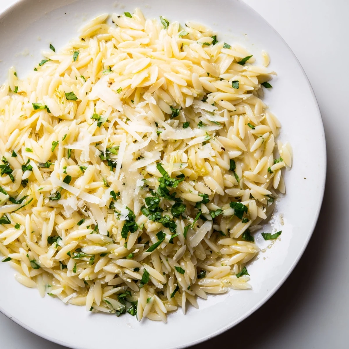 Orzo with lemon, herbs, and parmesan served in a vibrant, colorful bowl.  