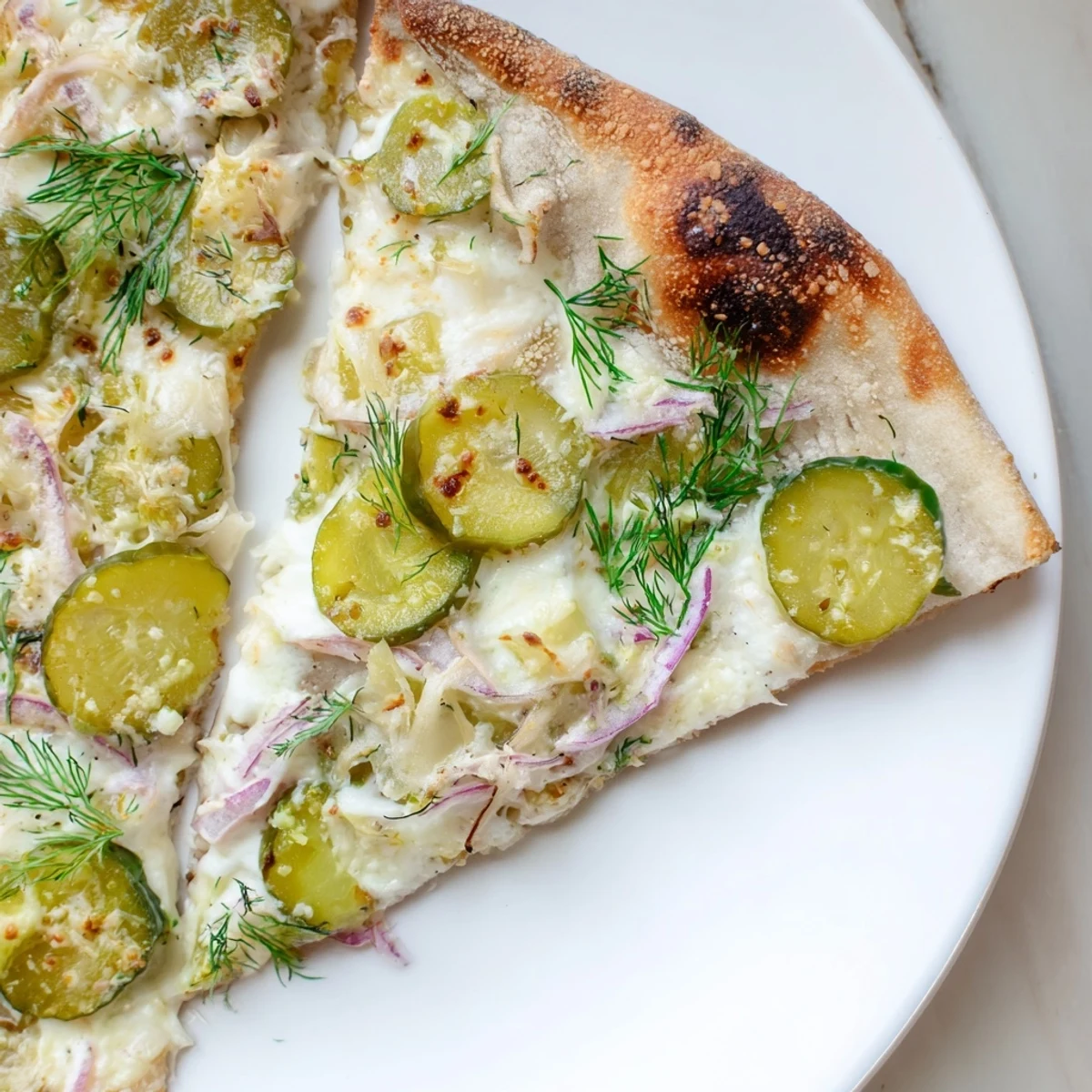 Tangy Pickle Pizza topped with creamy sauce, mozzarella, and crunchy dill pickles.  