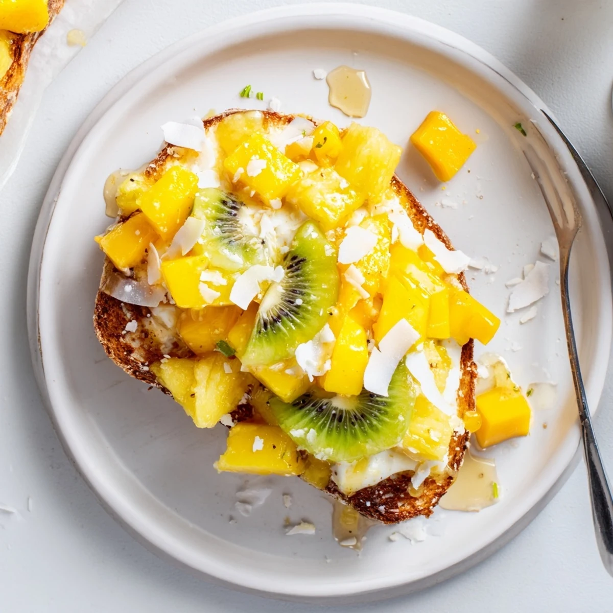 Creamy coconut yogurt custard toast, garnished with fresh mango, kiwi, and pineapple.  