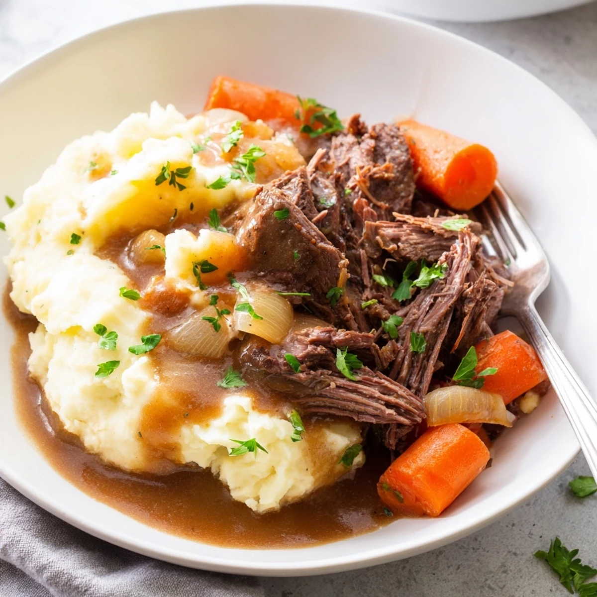 Mouthwatering slow cooker pot roast with vegetables and creamy mashed potatoes, garnished beautifully.  