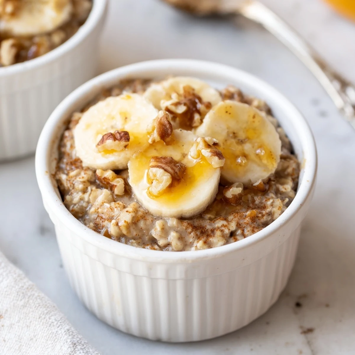 Golden-brown baked oats ramekins with banana slices and a generous honey drizzle for breakfast.
