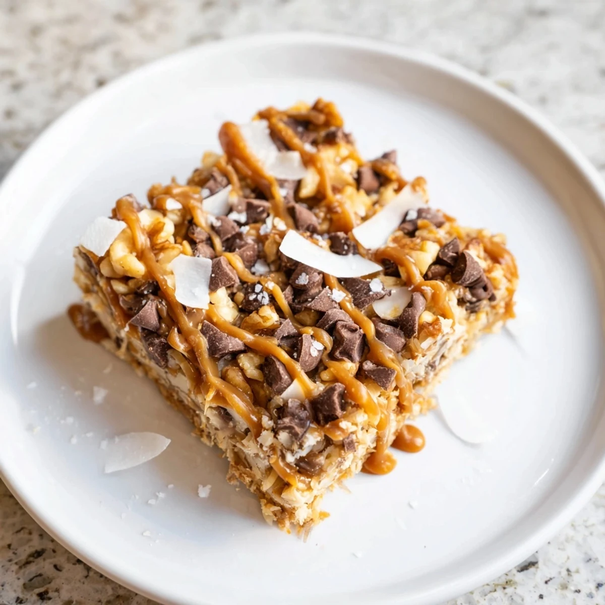 Chewy 7-Layer Magic Bars with drippy salted caramel, ready to be cut and served.