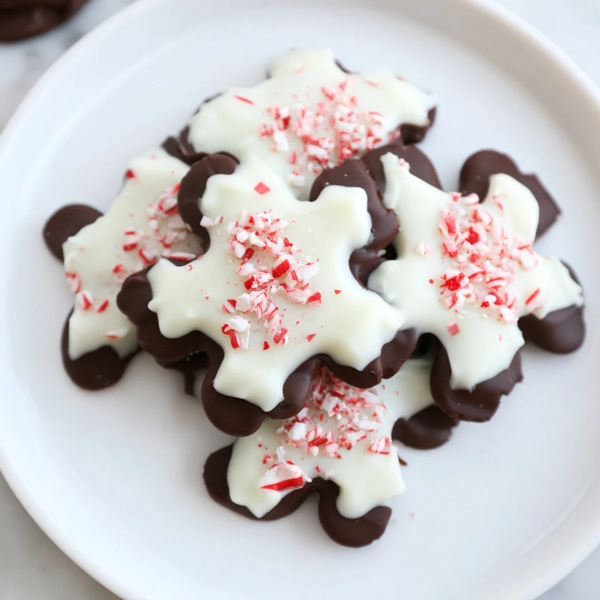 Beautifully arranged Peppermint Bark Snowflakes, a quick and easy dessert, ready for festive gifting or parties.