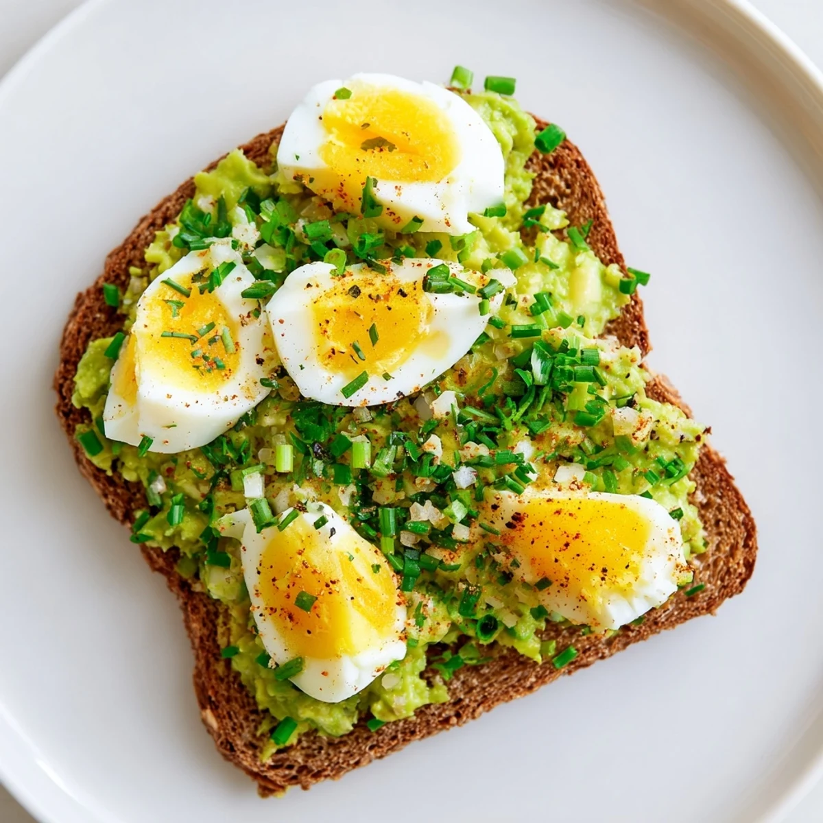 Creamy avocado egg smash on toasted bread, a bright and flavorful American breakfast.