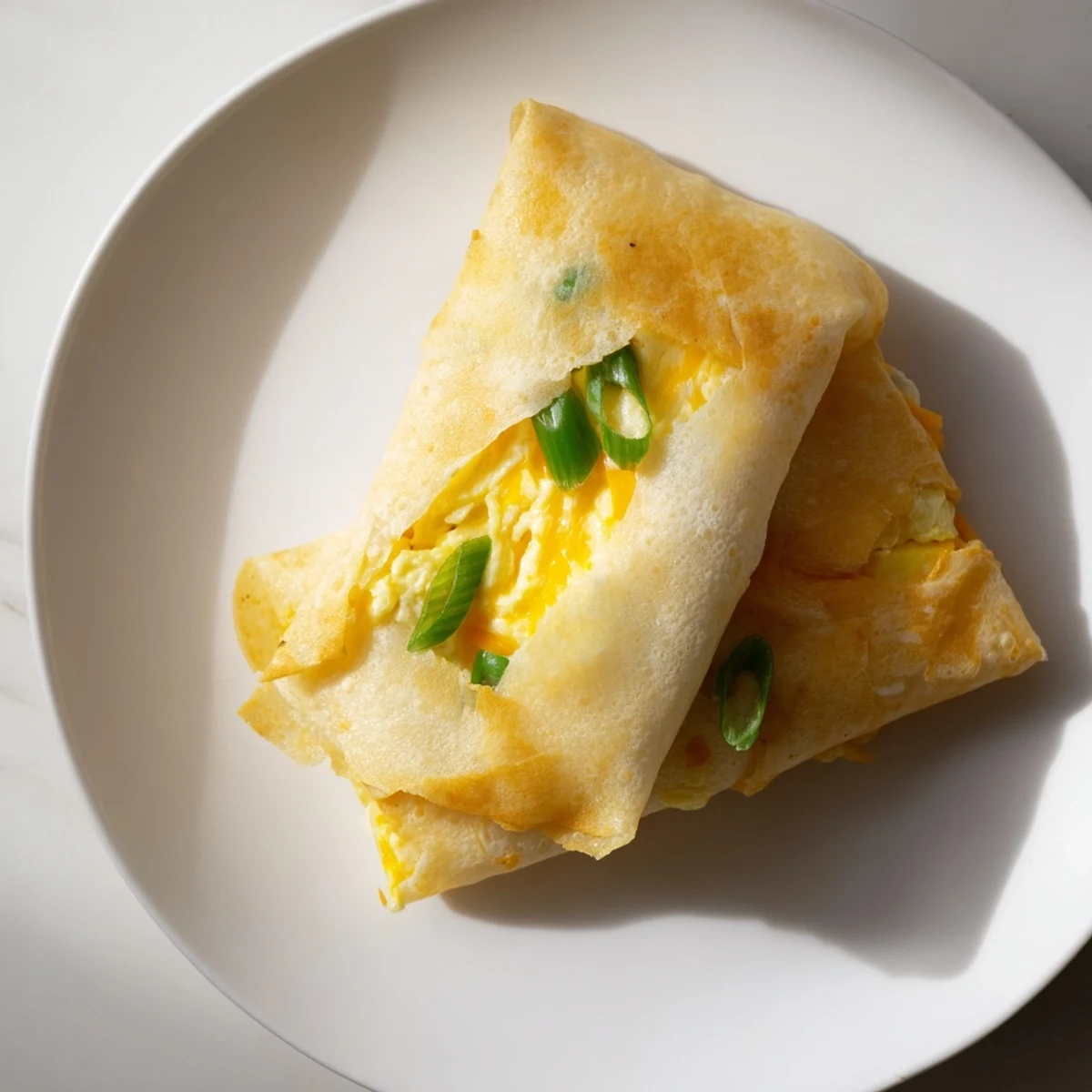 Golden, crispy rice paper egg & cheese fold, a quick, savory breakfast bursting with cheese.