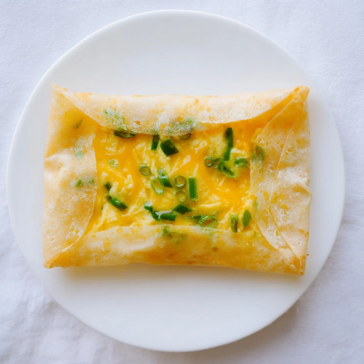 A close-up of a perfectly cooked rice paper egg & cheese fold, a quick snack idea loaded with flavor.