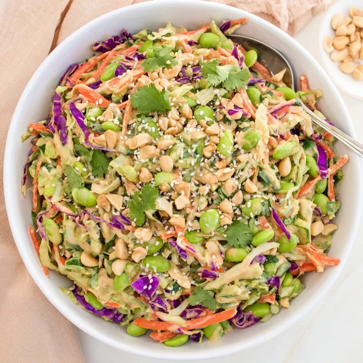 Lime wedges frame a bowl of the Crunchy Thai Peanut Salad, highlighting its crunchy textures and tangy peanut dressing for a light meal.