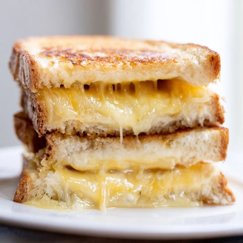 Air fryer grilled cheese perfection: ooey-gooey cheddar melting from a perfectly golden, crisp sandwich.