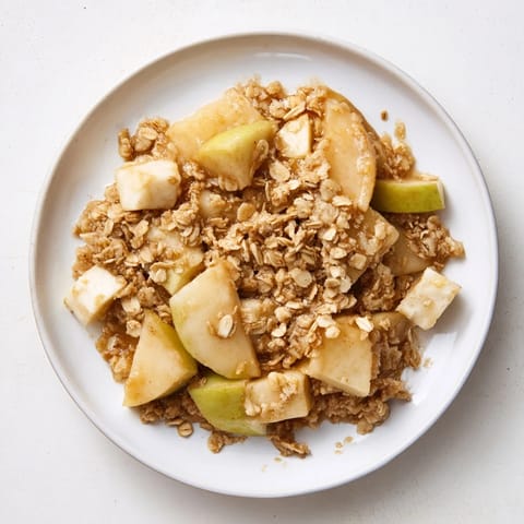 A close-up of a freshly baked Best Apple Crisp, showcasing tender apples under a crispy oat topping.