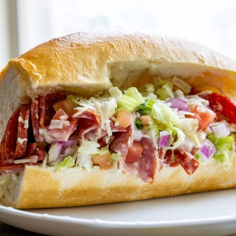 Warm, toasted hoagie roll overflowing with a flavorful Chopped Italian Grinder sandwich, a true delight.