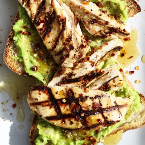 Smashed Avocado Chicken Toast features tender sliced chicken over lemony avocado mash on crisp sourdough.  
