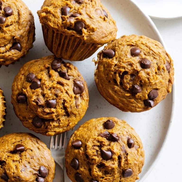 Freshly baked pumpkin chocolate chip muffins, oozing with rich dark chocolate goodness.  