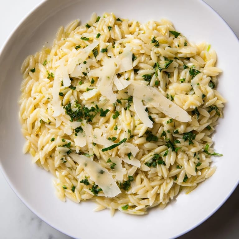 Freshly cooked orzo with lemon, herbs, and parmesan sprinkled with cheese and zest.