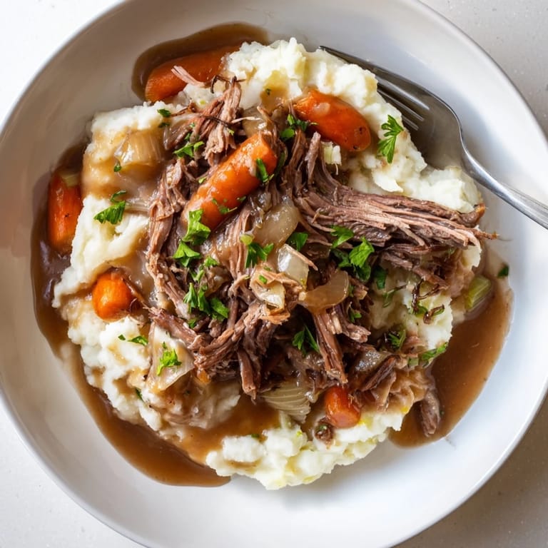 Tender slow cooker pot roast with rich gravy and buttery mashed potatoes, perfect for dinner.  