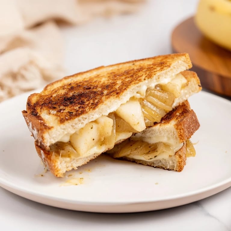 A close-up view of the rich, savory French onion grilled cheese, perfect for a cozy lunch.