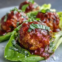 Juicy turkey meatballs in crisp lettuce cups with bright marinara, ready to eat.